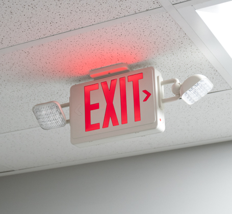 Red illuminated exit light sign with two strobe lights for emergency evacuations.